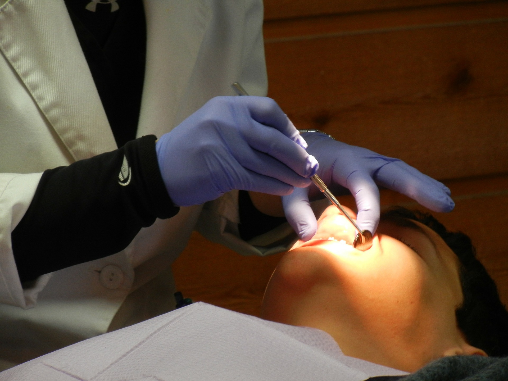 Dentiste qui examine la bouche d'un patient